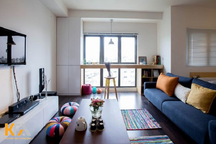 Bộ sofa được chọn tông màu trầm đơn giản cùng bộ gối màu sắc tạo điểm nổi bật cho phòng khách